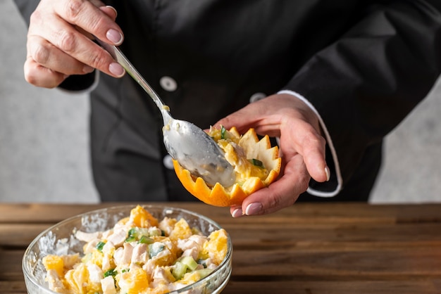 Free Photo high angle of chef filling orange with dish