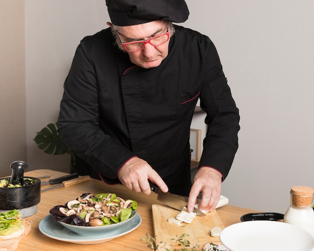 High angle chef slicing ingredients for salad