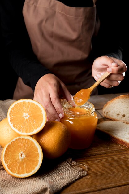 High angle of chef with jar of orange mnarmalade