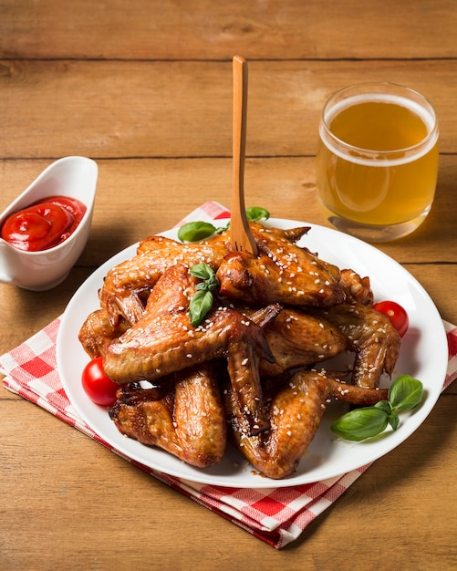 Free photo high angle chicken wings on plate with sesame seeds and ketchup