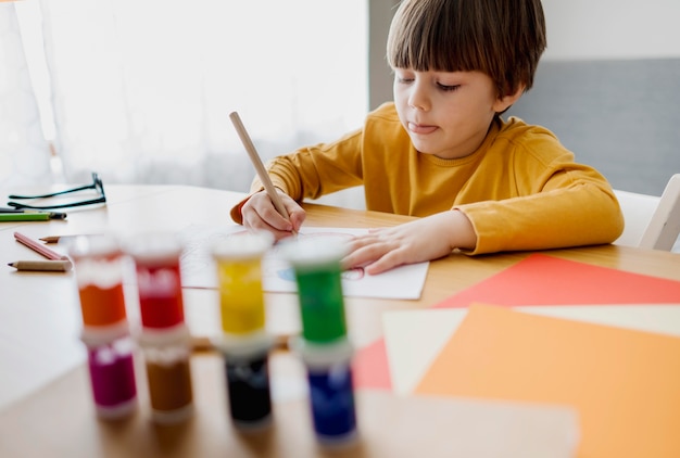 High angle of child drawing and learning at home