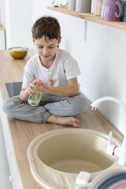 High angle of child using liquid soap