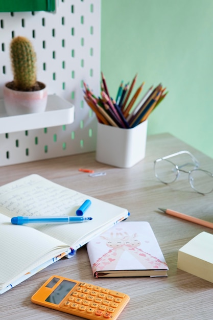 High angle of children's desk with calculator and notebook