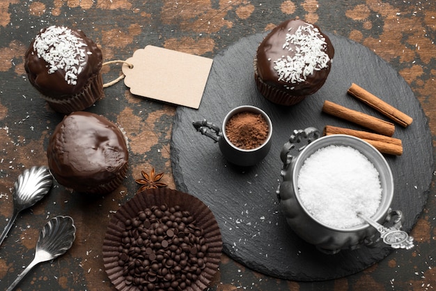 Free photo high angle of chocolate desserts with coconut flakes and cinnamon sticks