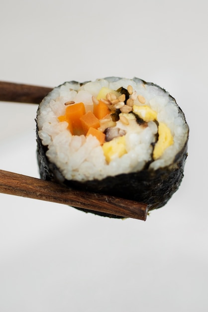 High angle chopsticks holding sushi