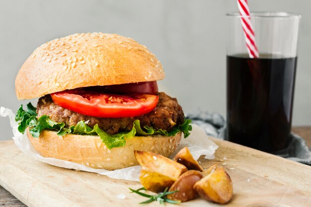 High angle close-up of burger and fries on wooden board