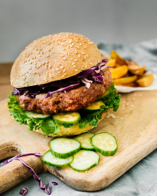 High angle close-up burger with fries on wooden board