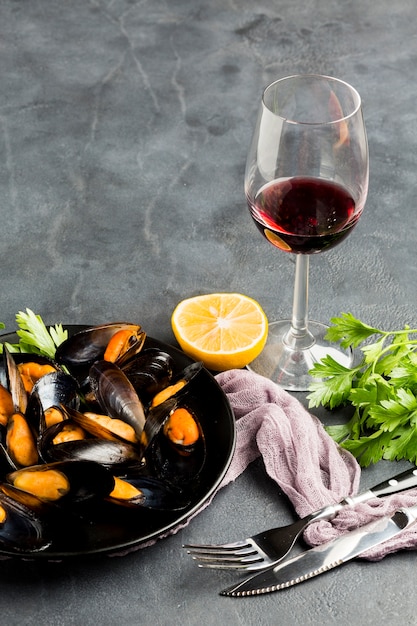 Free photo high angle close-up cooked mussels and wine bottle