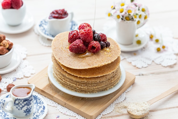 Free Photo high angle closeup shot of raw vegan pancakes with honey and berries