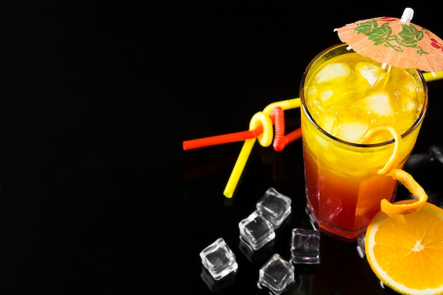 Free photo high angle of cocktail with umbrella and ice cubes