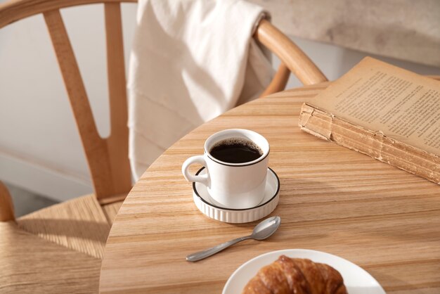 High angle coffee cup and book on table