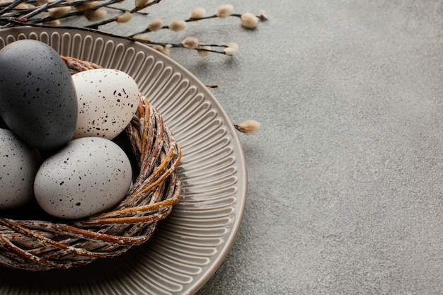 Free photo high angle of colored easter eggs in basket with copy space