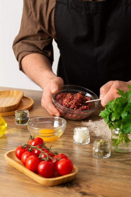 Free Photo high angle cook preparing beef steak tartar