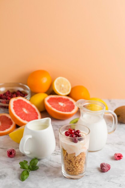 High angle cornflakes and yogurt in glass with mik of fruits