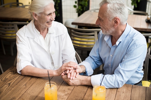 Free photo high angle couple holding hands at restaurant