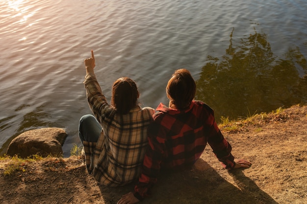 High angle couple sitting by the lake