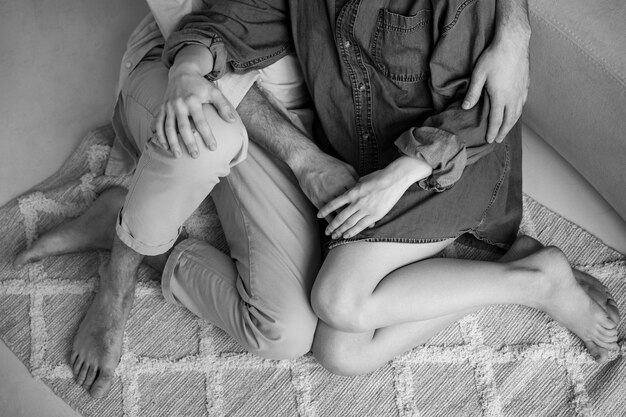 High angle couple sitting on floor black and white