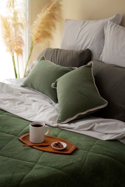 Free photo high angle cozy bed arrangement with coffee cup