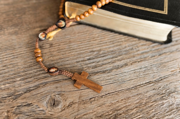 Free photo high angle of cross rosary with holy book