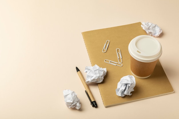 Free photo high angle crumpled paper and coffee cup