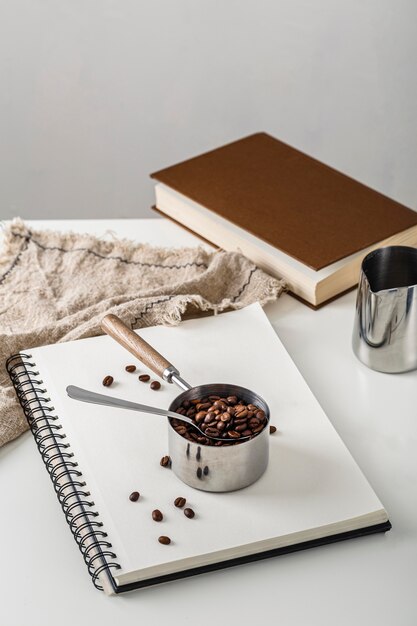 High angle of cup with coffee beans on notebook