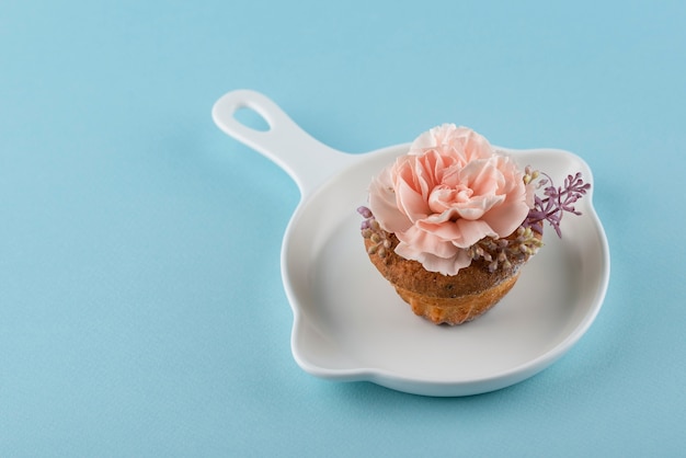 Free Photo high angle cupcake with flower and blue background