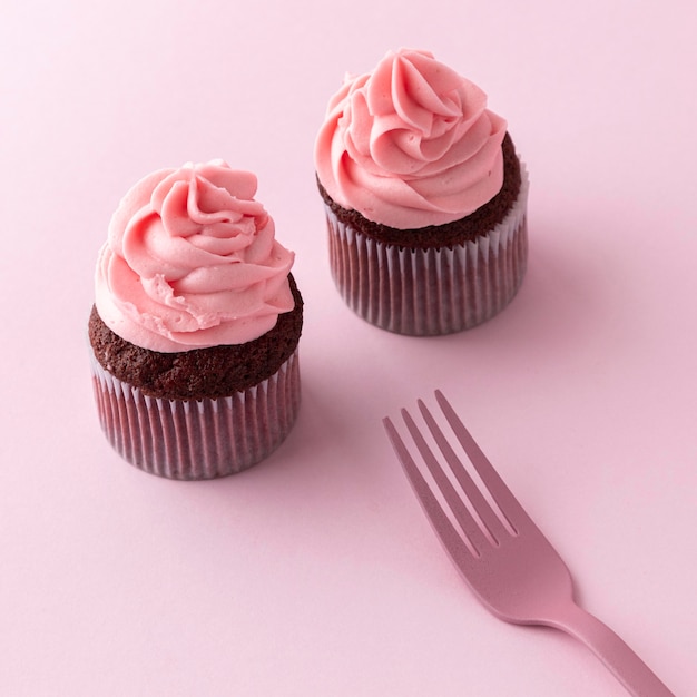 High angle cupcakes with pink icing and fork