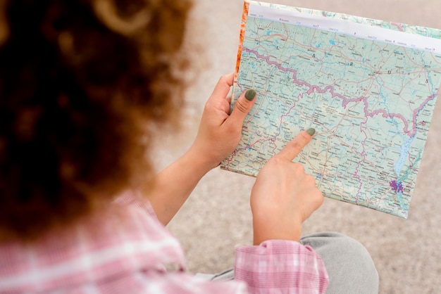 Free Photo high angle curly woman checking her map