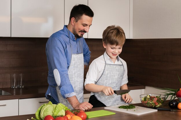 High angle dad and son cutting vegetables