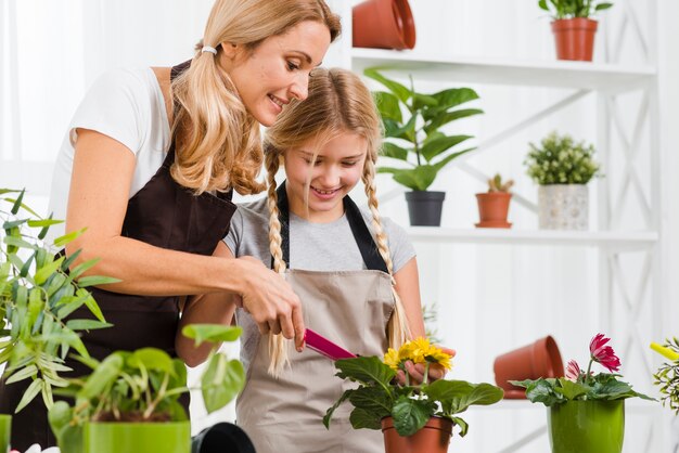 High angle daughter helping mom in greenhouse