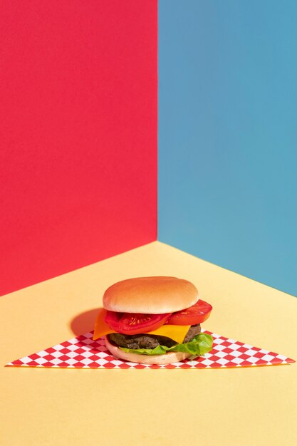 High angle decoration with tasty cheeseburger on yellow table 