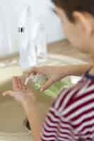 Free photo high angle of defocused kid using liquid soap