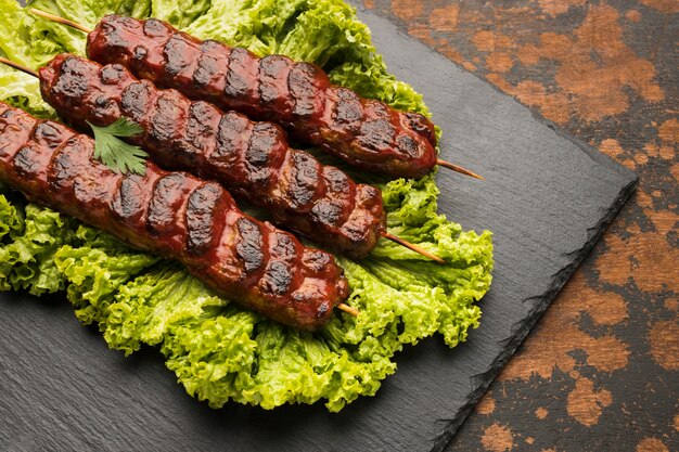 High angle of delicious kebab on slate with salad