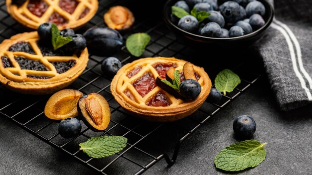 High angle of delicious pies with plums on cooling rack