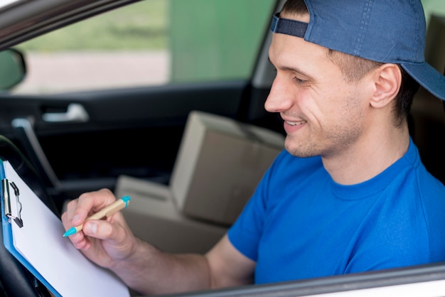 Free photo high angle delivery man signing paper