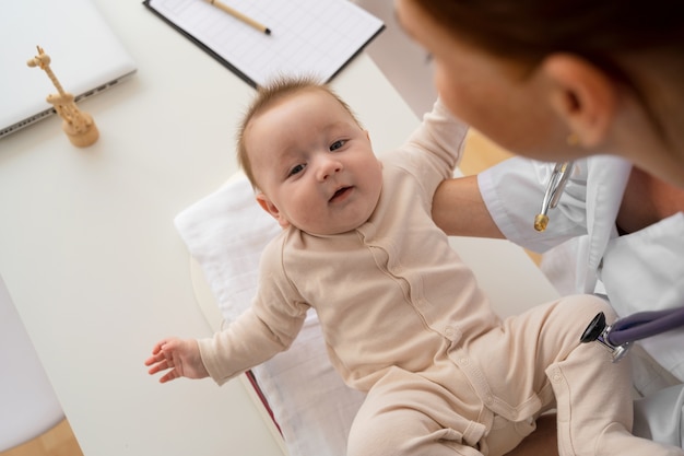 Free photo high angle doctor holding baby