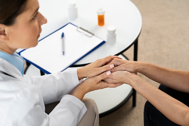 High angle doctor holding patient's hands