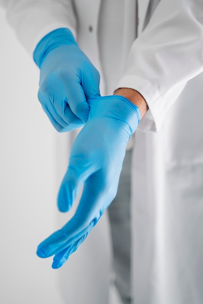 Free photo high angle doctor putting on gloves