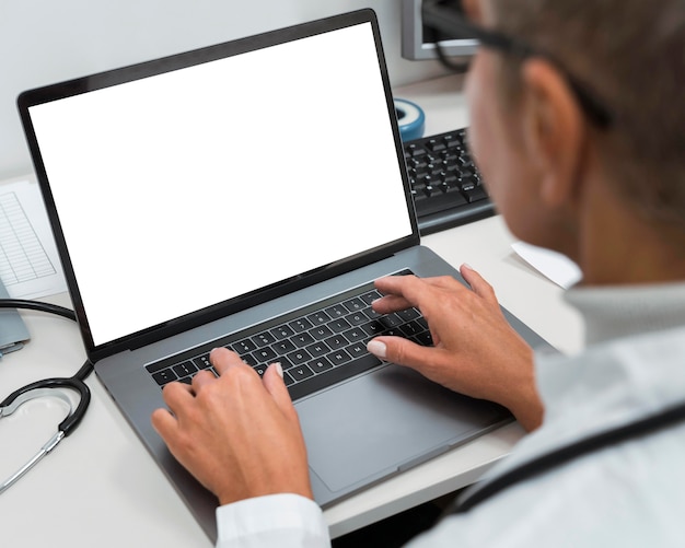 High angle doctor working on a laptop