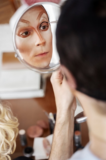 High angle drag queen holding mirror