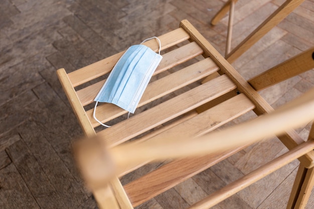 High angle of empty chair with medical mask prepared for group therapy session