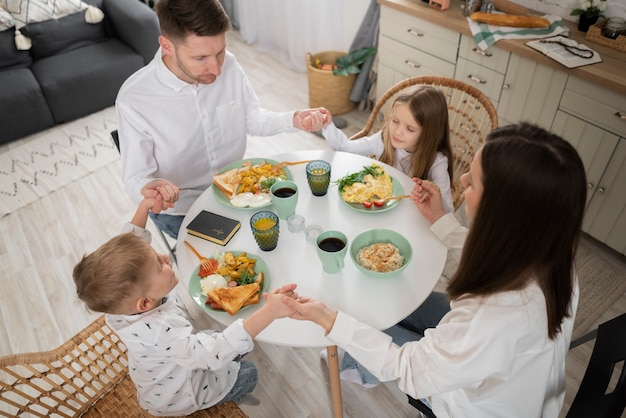 High angle family praying at table