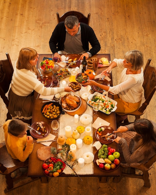 Free Photo high angle family sitting at dinner table