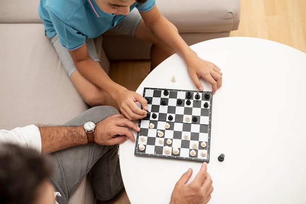 Free photo high angle father and child playing chess