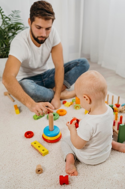 High angle of father playing with baby at home