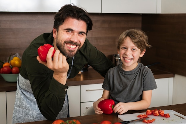 High angle father and son holding vegetables