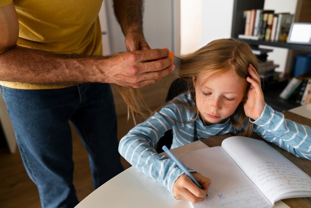 High angle father using lice comb