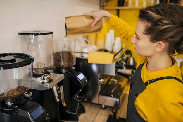 High angle of female barista grinding coffee