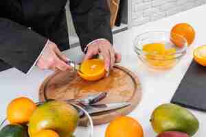 Free photo high angle of female chef cutting an orange