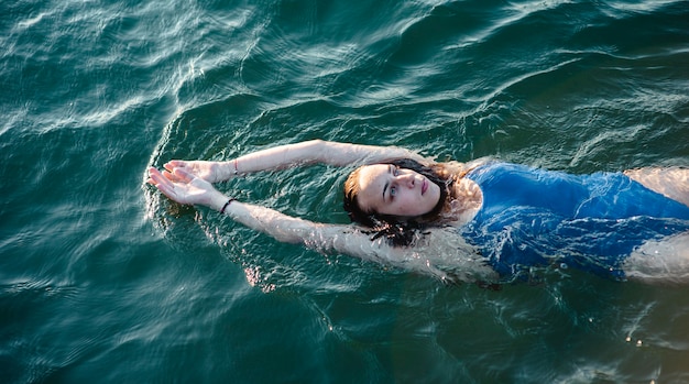 Free photo high angle of female swimmer floating on water